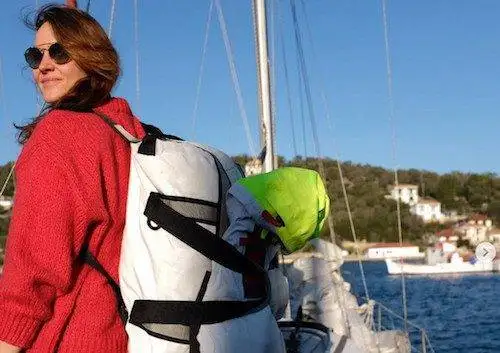 a woman on a sailboat with a backpack on her back.