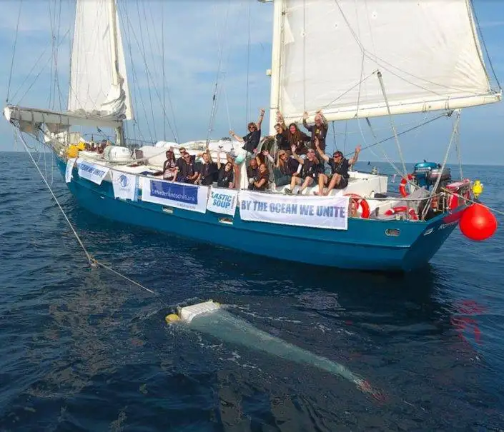 a group of people on a sailboat in the ocean.