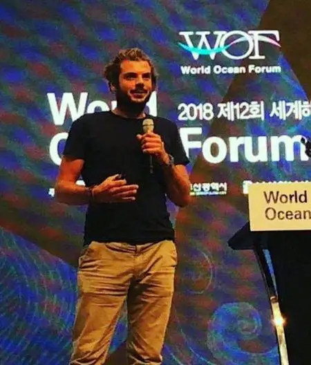 a man giving a speech at the world ocean forum.