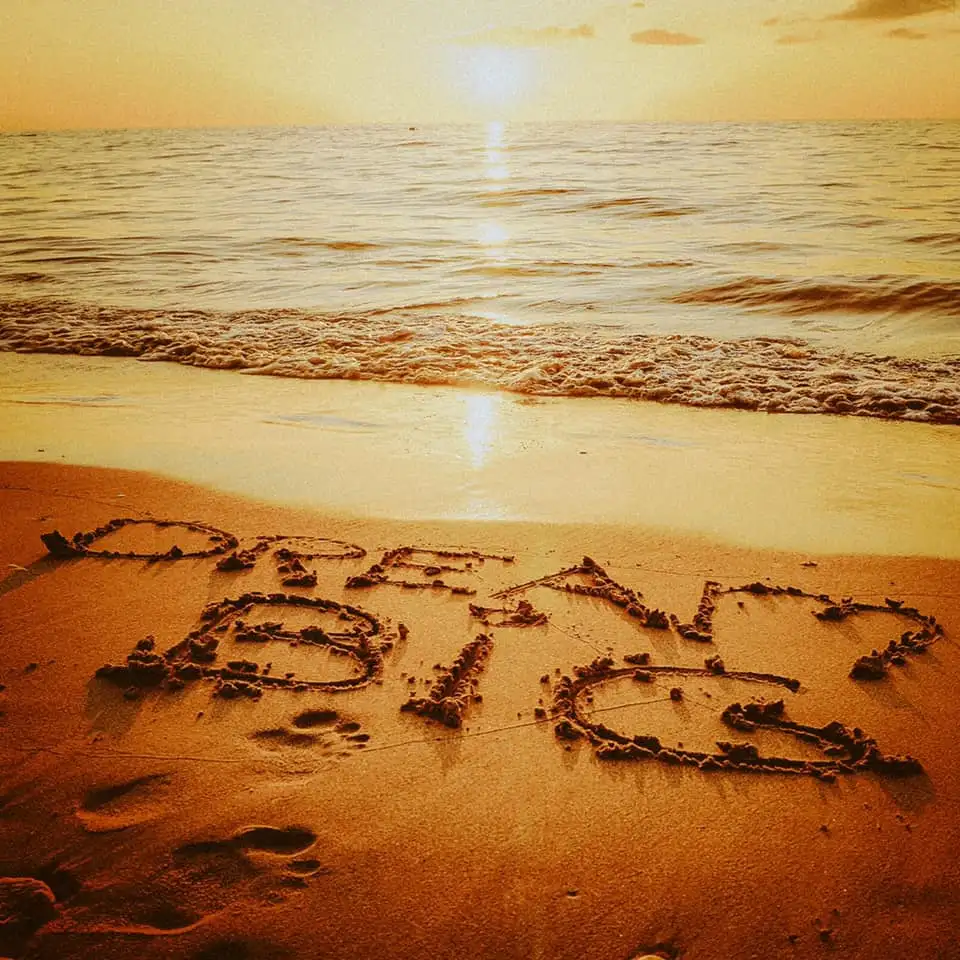 sand on a beach with the word dream big written in it.