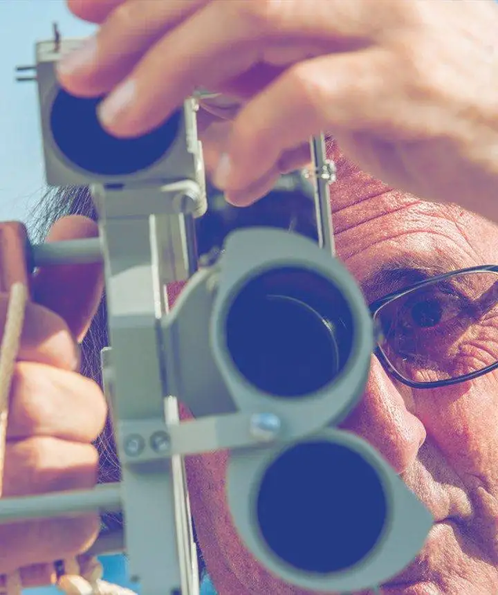 a man is looking through a telescope.