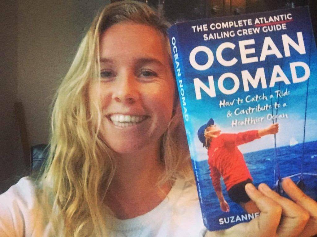 a woman holding up an ocean nomad book.