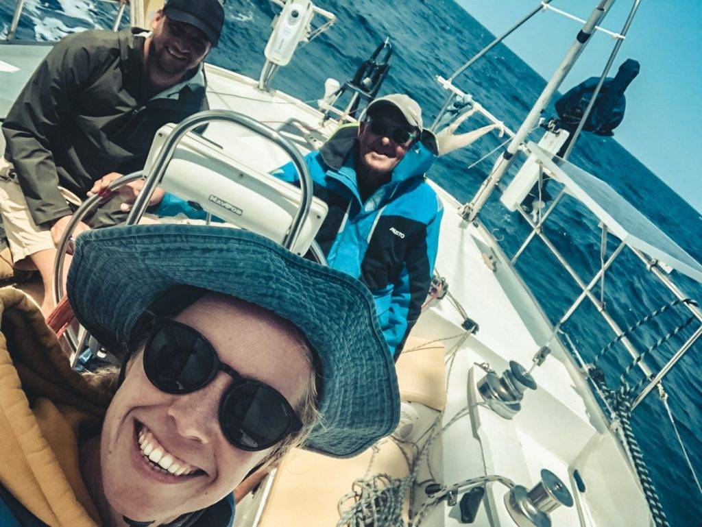 a group of people on a sailboat taking a selfie.
