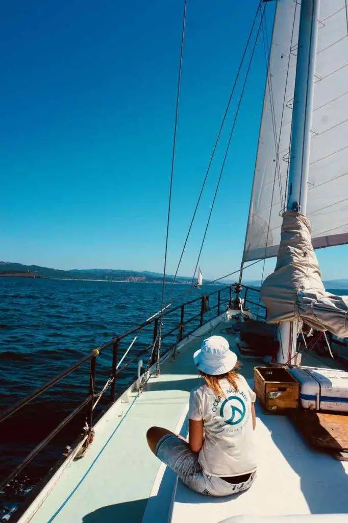 a woman sitting on the deck of a sailboat.