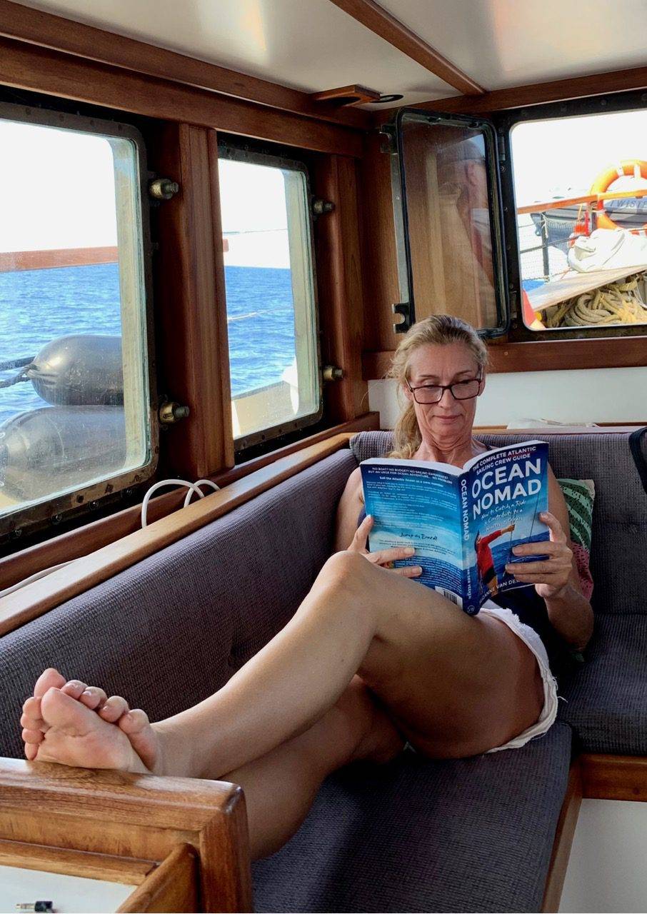 a woman sitting on a boat reading a book.