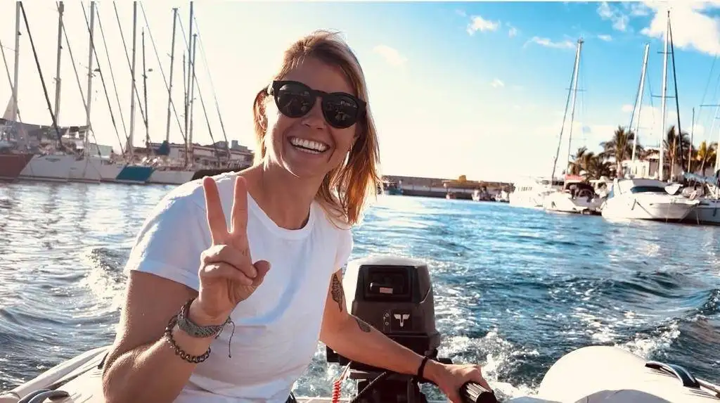 a woman is riding a boat with a peace sign on her face.