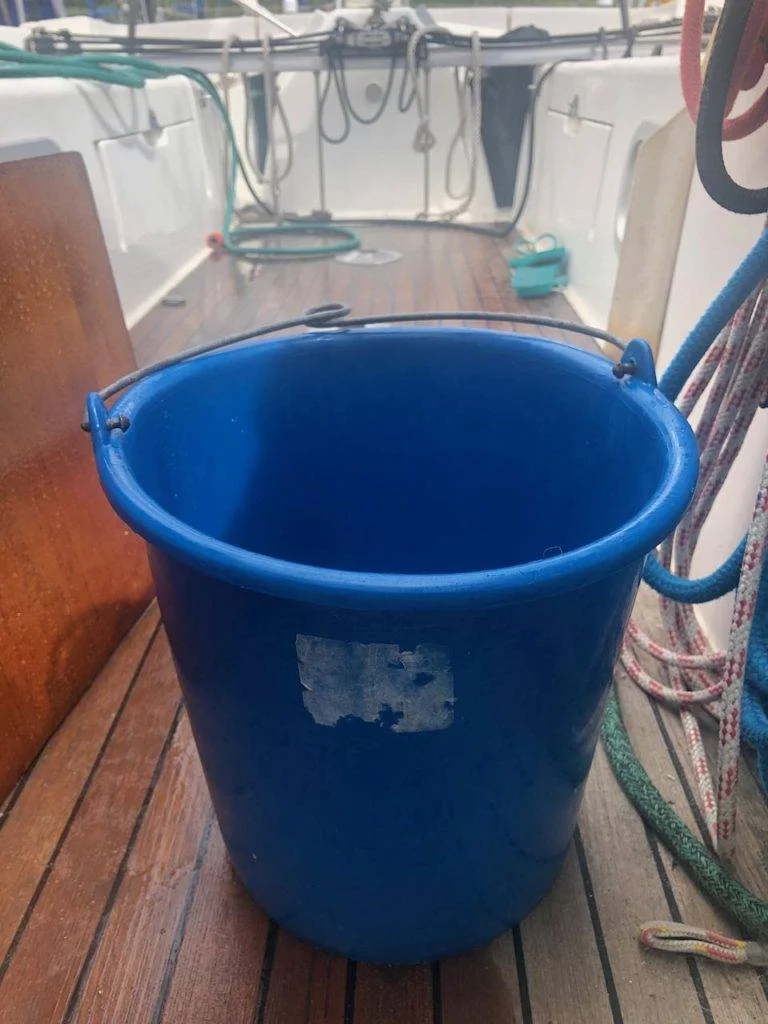 a blue bucket sitting on the deck of a boat.