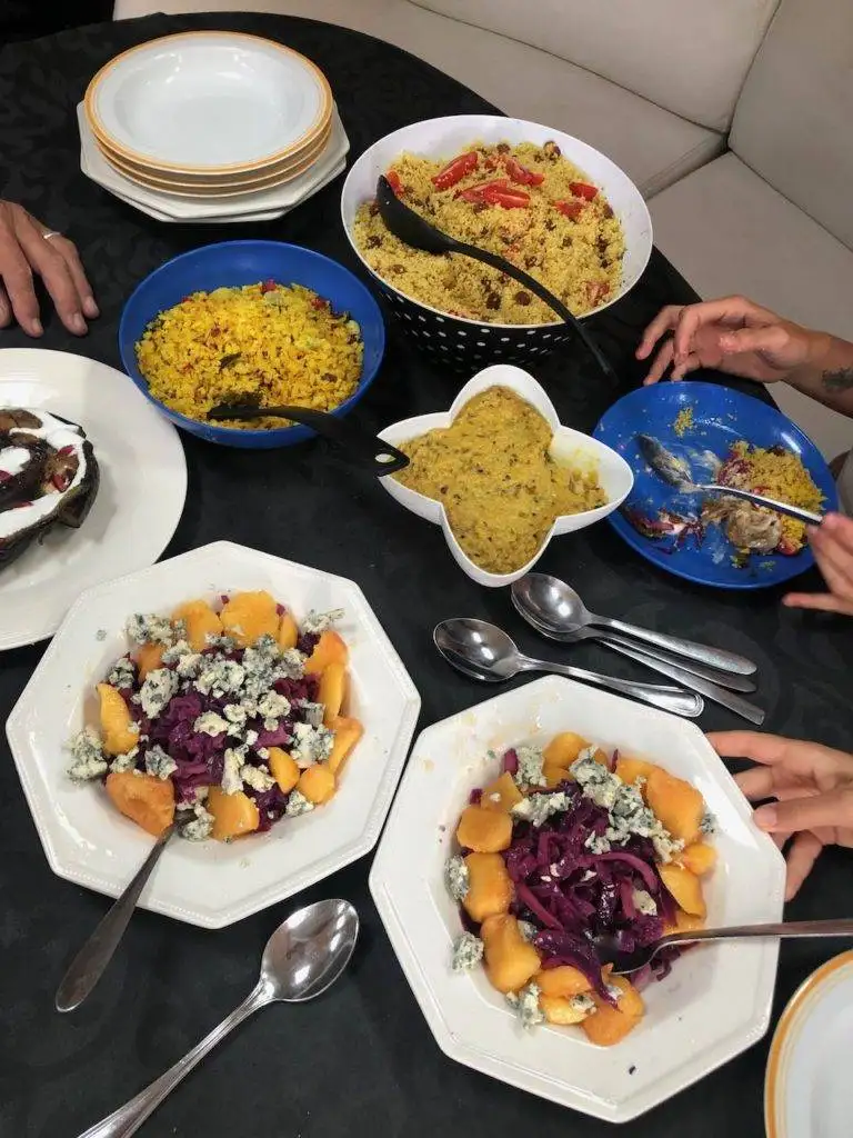 a group of people sitting around a table with plates of food.
