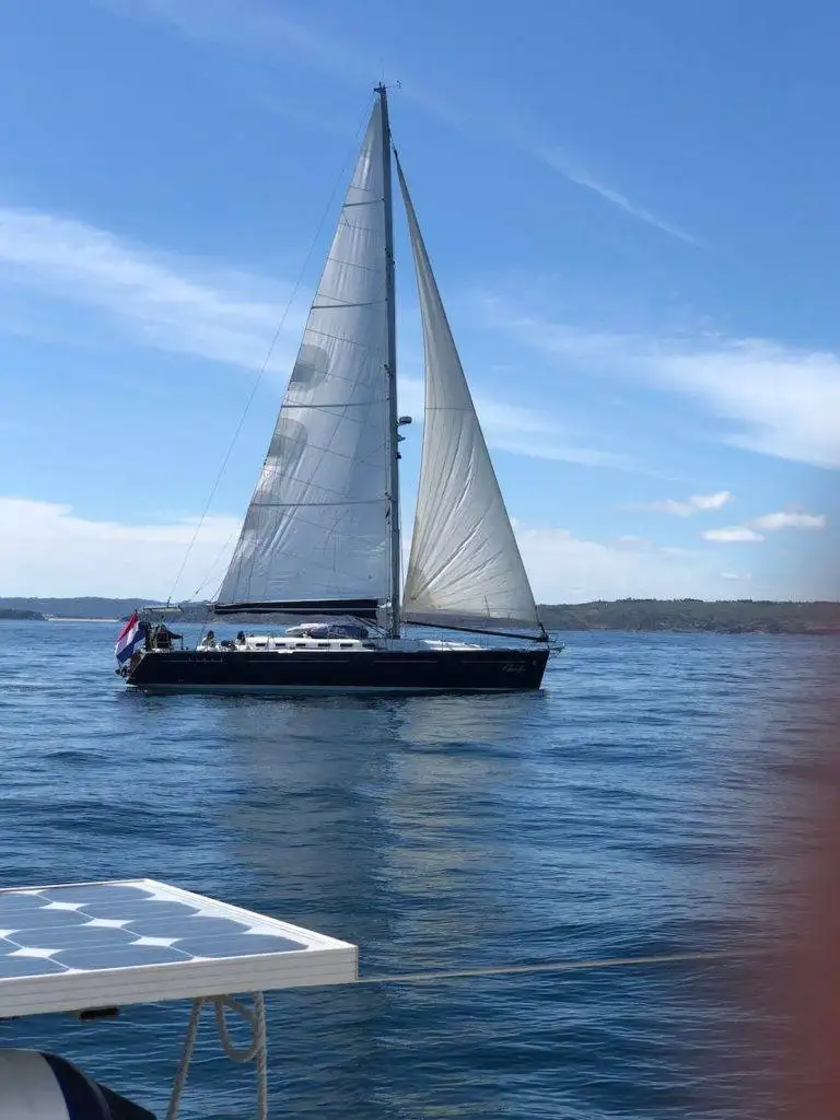 a sailboat with a white sail in the water.