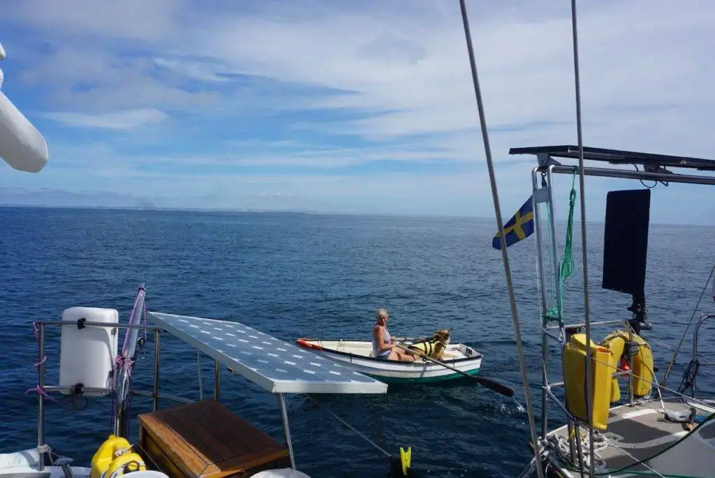 a boat in the ocean with a person in a small boat.