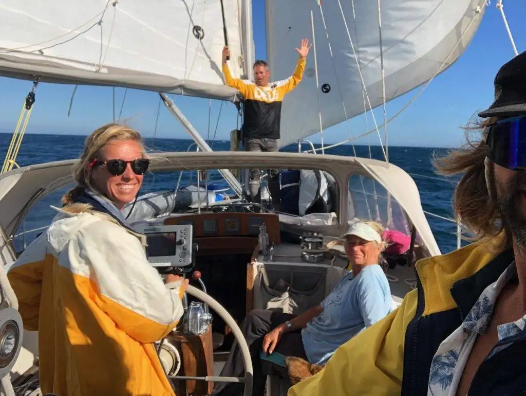 a group of people on a sailboat in the ocean.