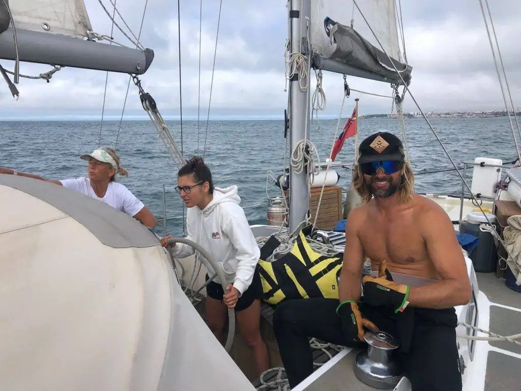 a group of people on a sailboat in the ocean.