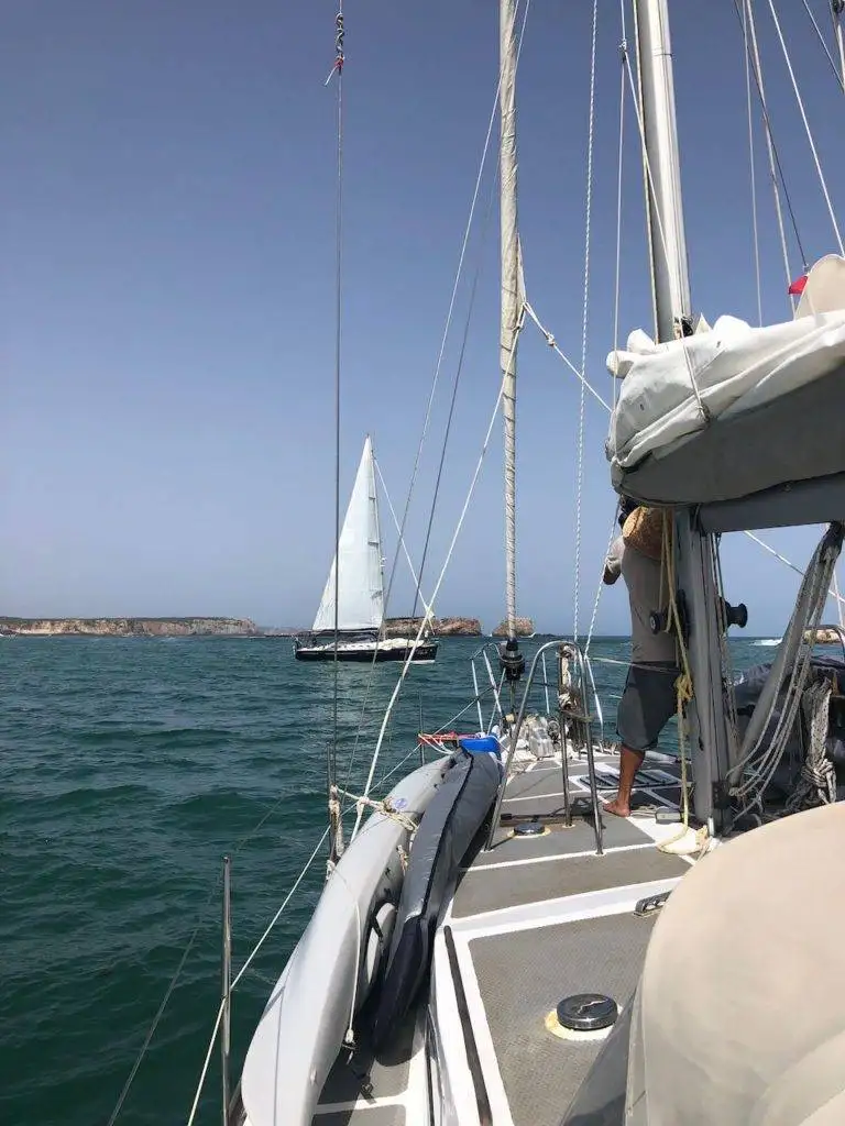 the back of a sailboat with a sail in the water.