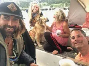 a group of people on a boat with a dog.