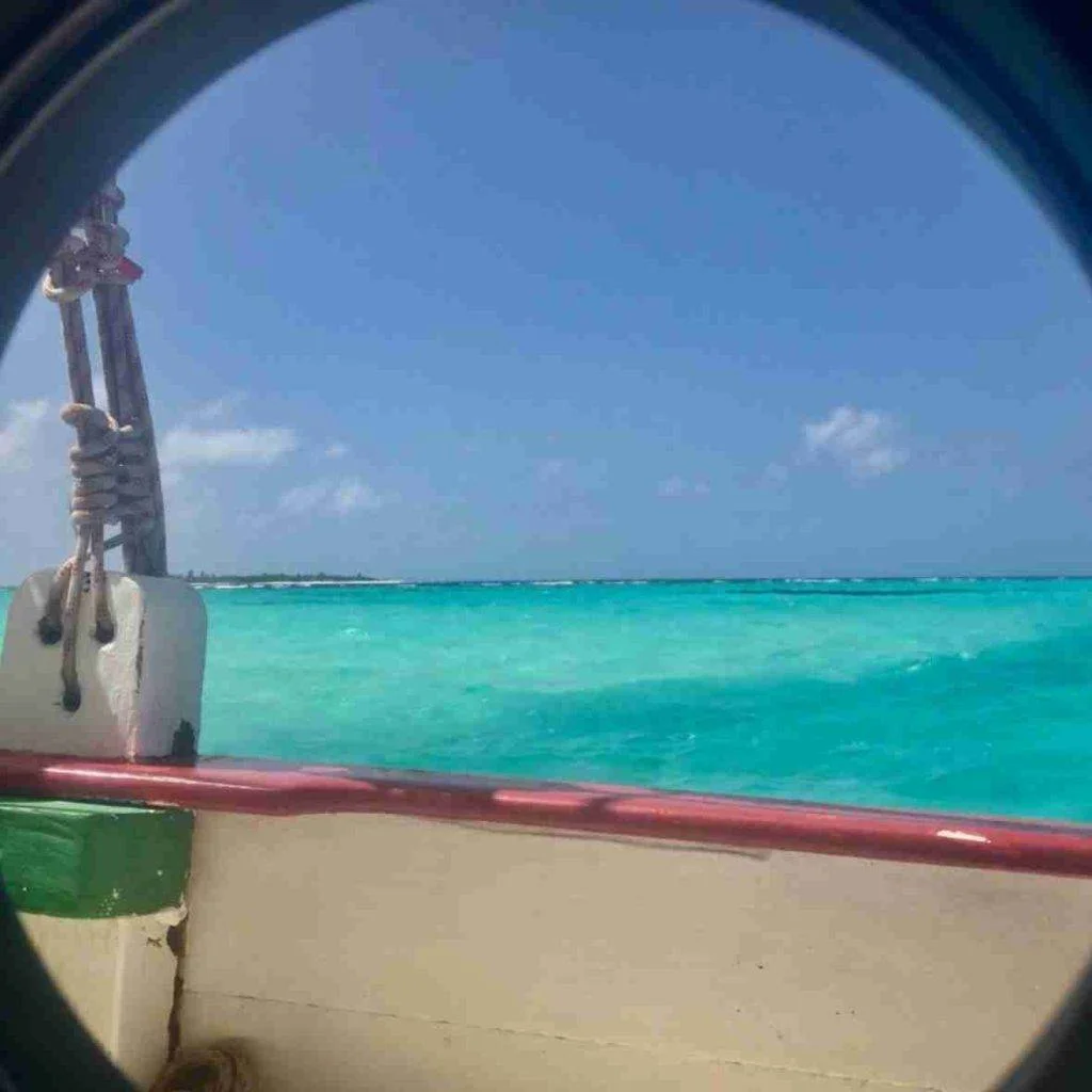 a view of the ocean through a hole in a boat.