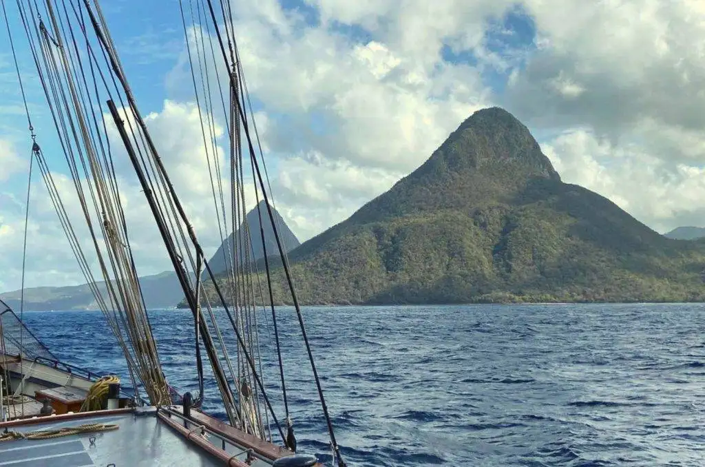 the view from the deck of a sailboat with a mountain in the background.