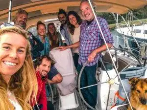 a group of people on a sailboat with a dog.