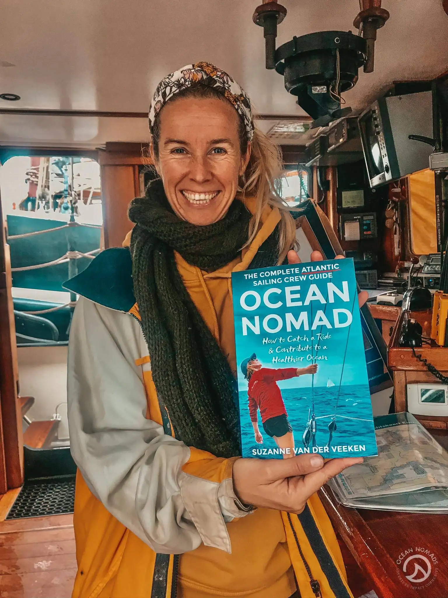 a woman holding up a book called ocean nomad.