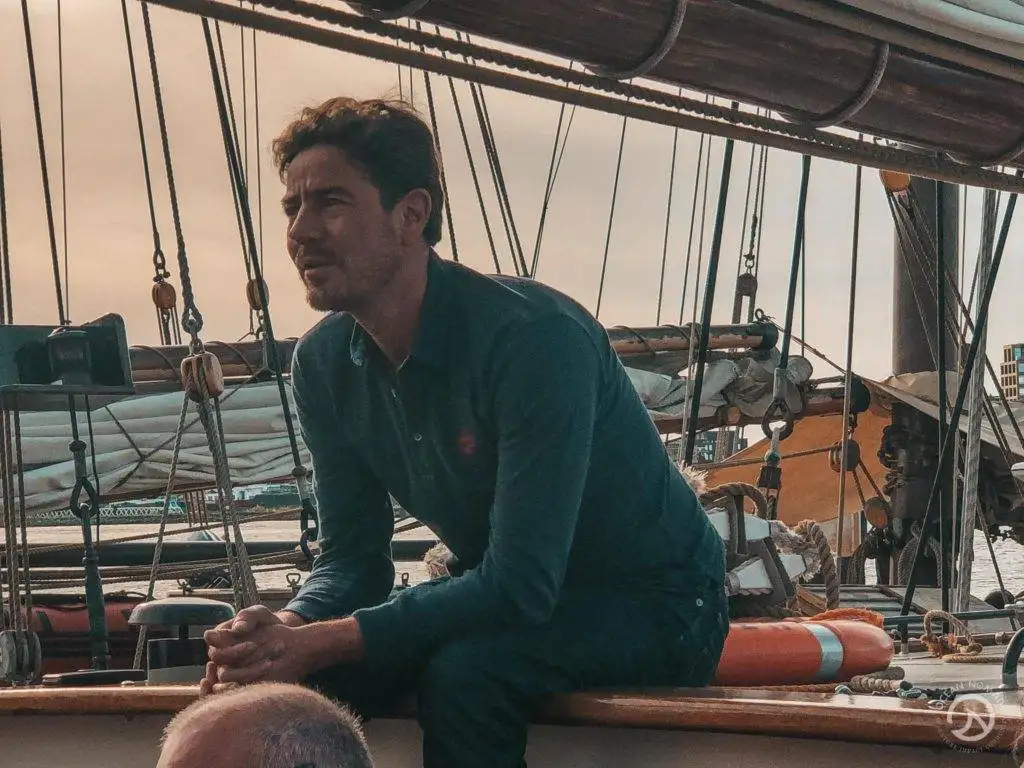 a man sitting on the deck of a sailboat.