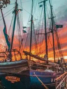 a sailboat docked at a dock at sunset.