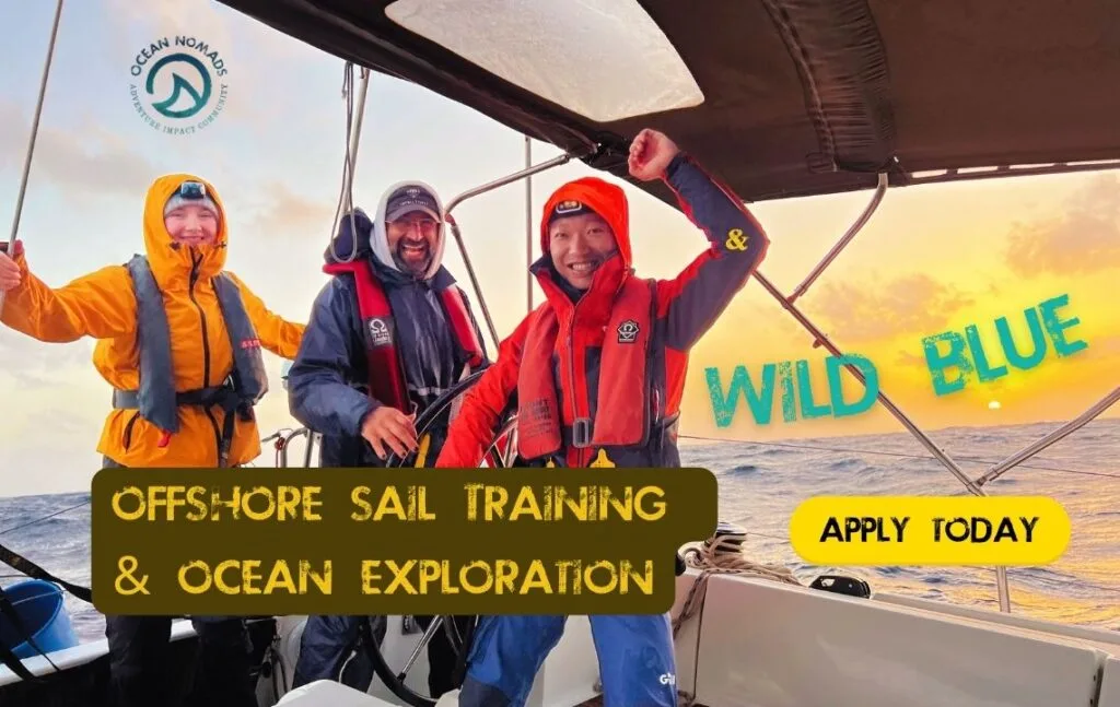 Three people in rain jackets smiling on a sailboat at sunset. Text reads: "Offshore Sail Training & Ocean Exploration from the Canary Islands to Cape Verde. Wild Blue. Apply Today.